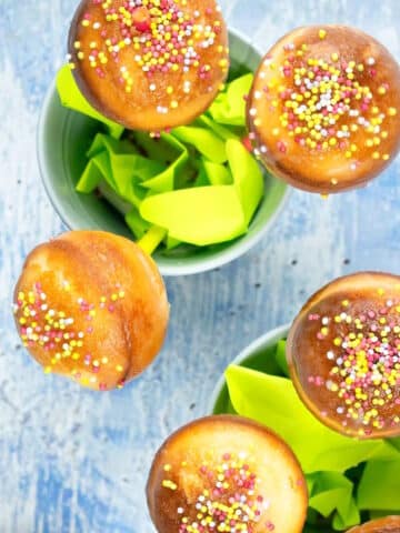 Cake mix cake pops in small pails with sprinkles on top.