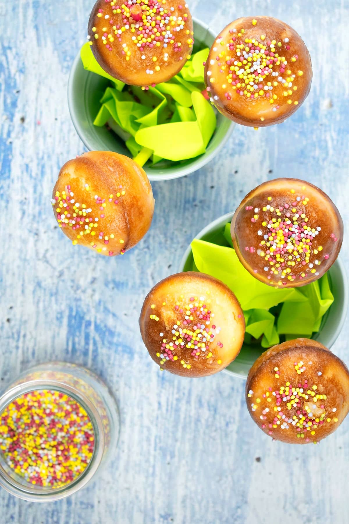 Cake mix cake pops with sprinkles in small, blue, decorative pails.