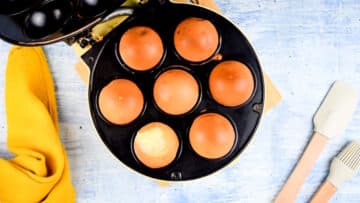Cake pop maker with baked cake balls in it.