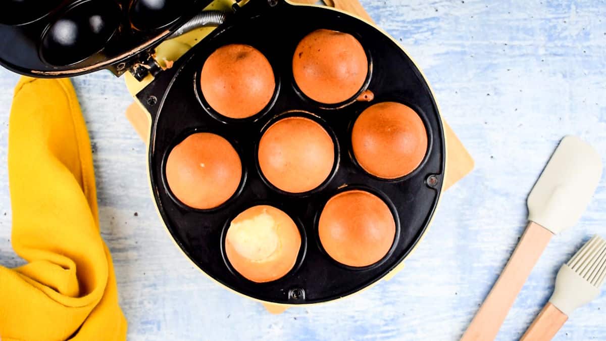 Cake pop maker with baked cake balls in it.