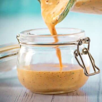 Chipotle sauce pouring from blender into jar.