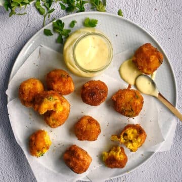 Corn nuggets on plate with dip.