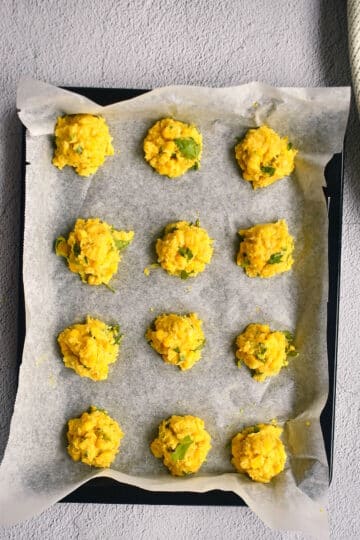 Raw corn nuggets on baking sheet with wax paper.