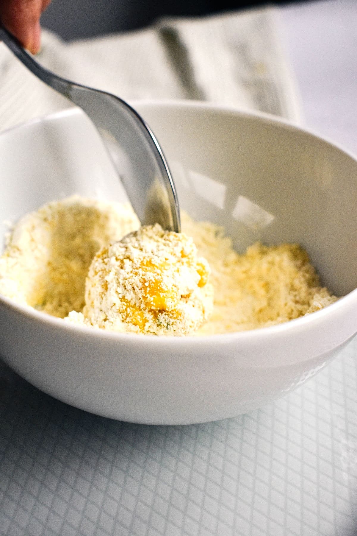 Raw corn nugget in bowl of flour.