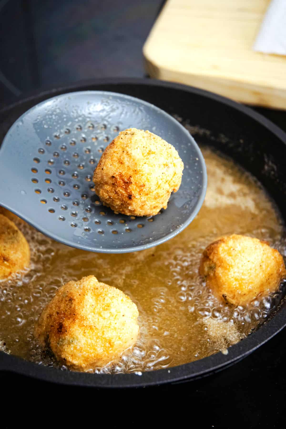 Golden corn nuggets in frying pan.
