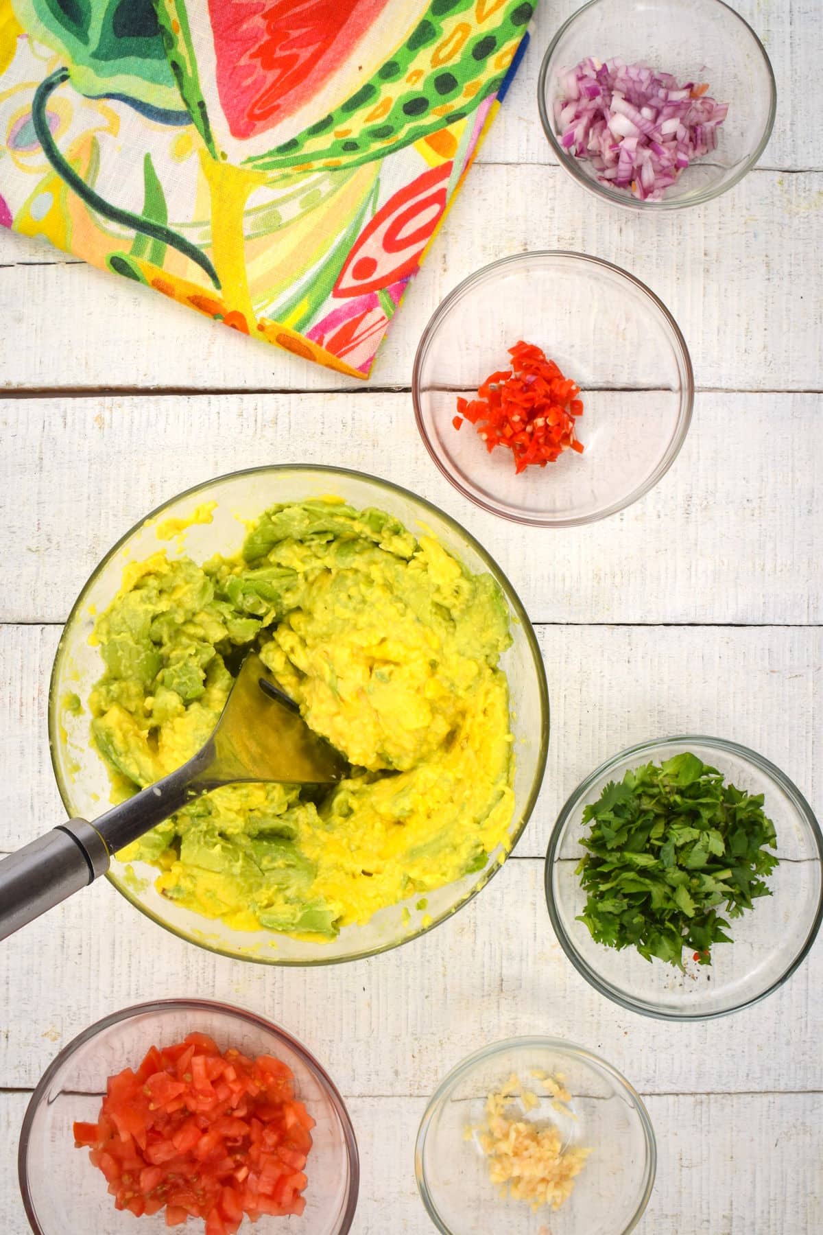 Smashed avocado and guacamole ingredients in bowls.