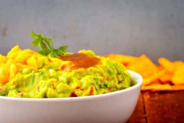 Mango and passion fruit guacamole in white bowl.