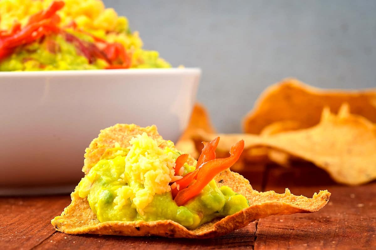 Spicy guacamole on a tortilla chip.