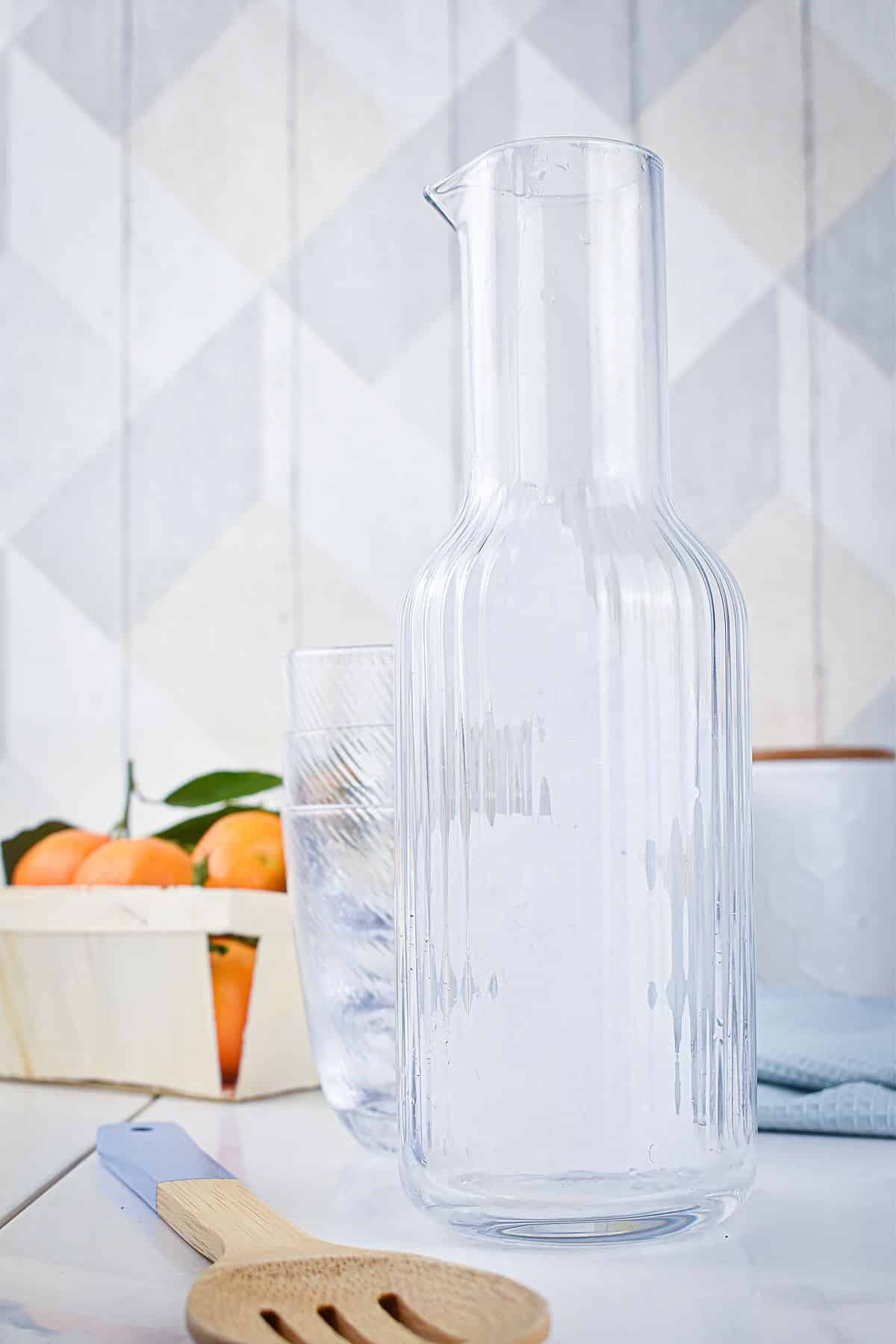 Empty pitcher, glass and fruit.