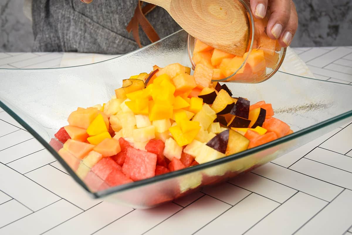 Cubed fruit combined in a glass dish.