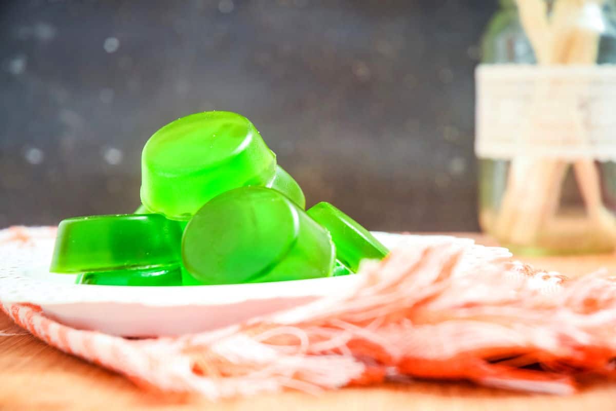 Green homemade gummies on plate.