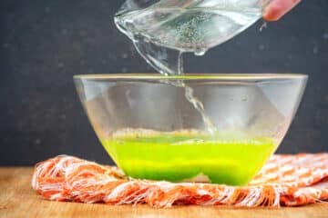 Green jello powder and warm water in small bowl.