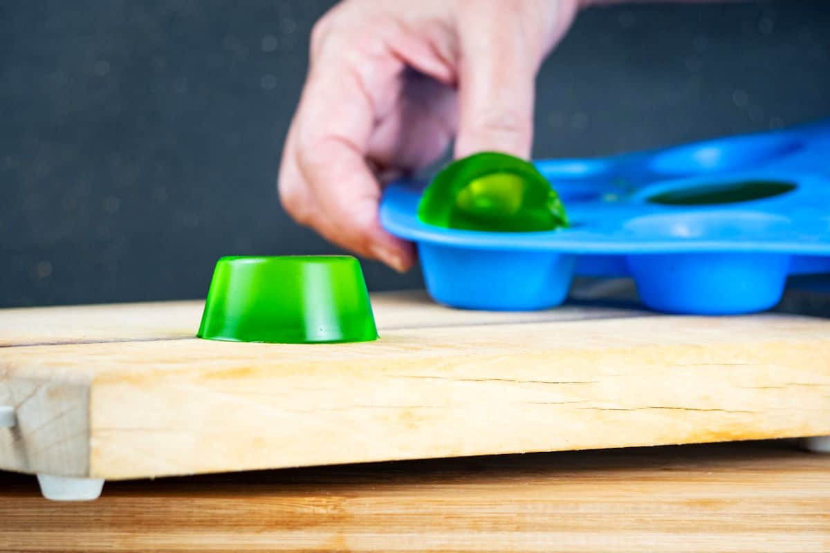 Green gummies on cutting board and in mold.