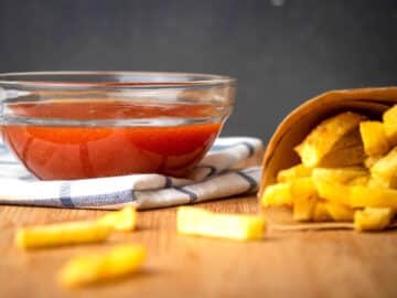 Homemade ketchup in a bowl with fries on the side.