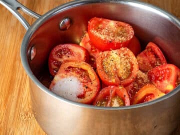 Fresh tomatoes and spices in a saucepan.