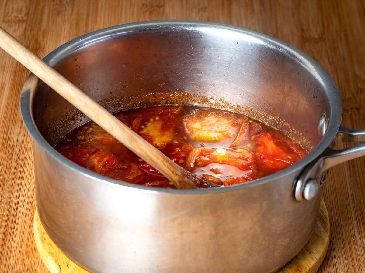 Tomatoes simmering in saucepan.
