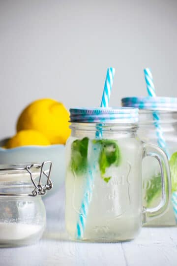 Lemonade in jars with fresh basil.