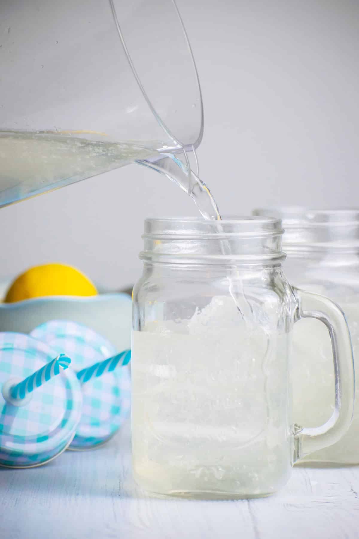 Lemonade pouring into ice-filled glass.