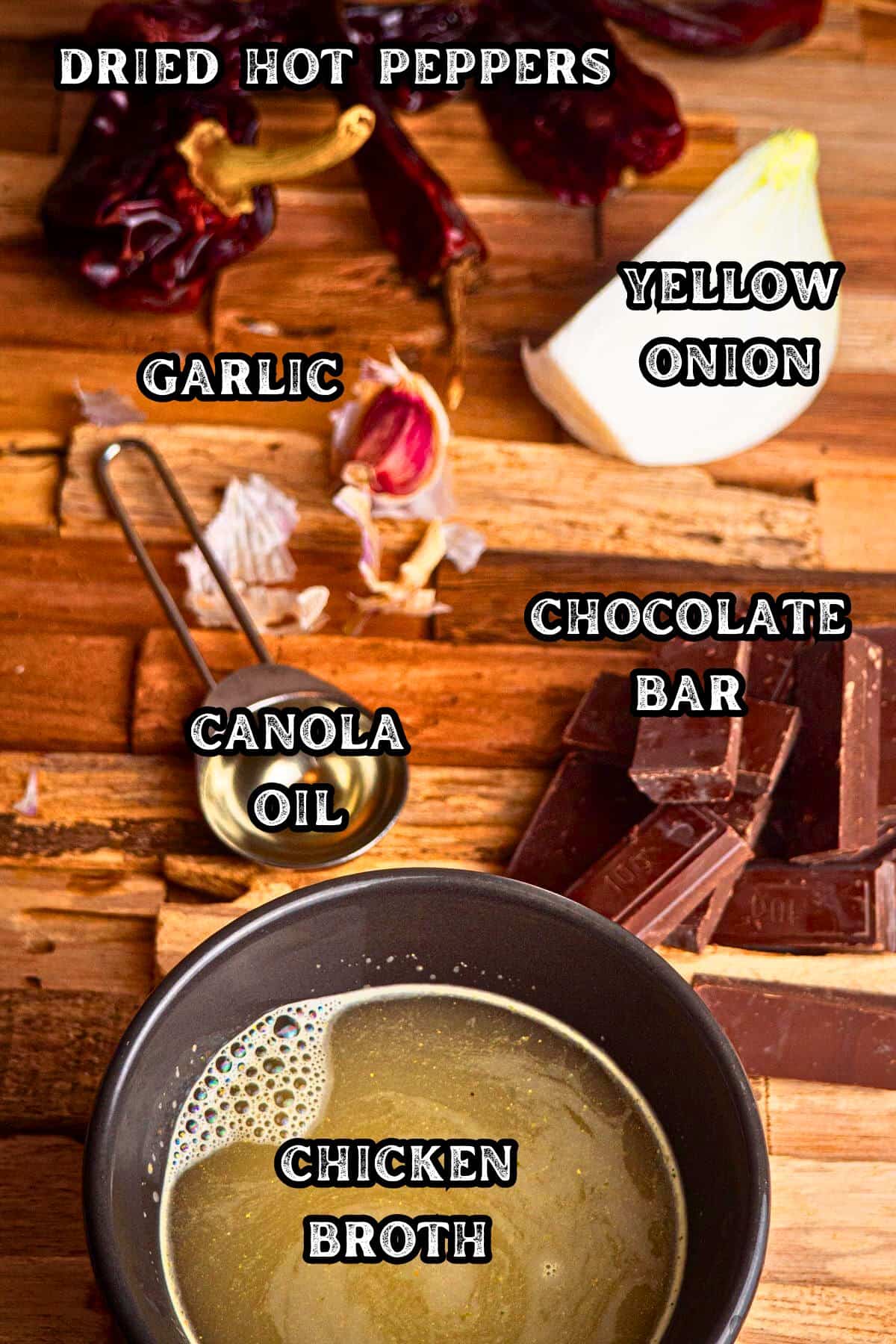 Mole sauce ingredients prepped and labeled on wooden background.