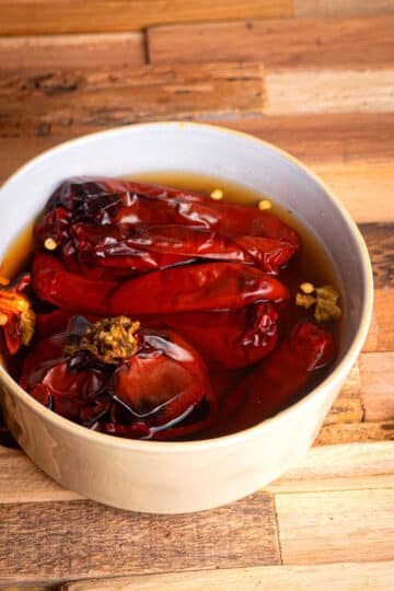 Chili peppers soaking in a bowl filled with water.