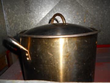 Pot of maple water with lid on woodstove.