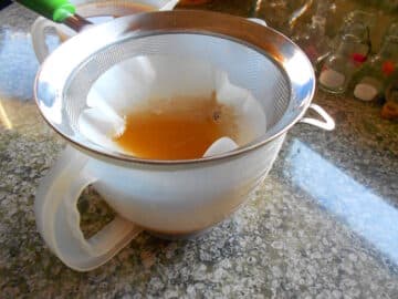 Cooked down maple water in strainer.