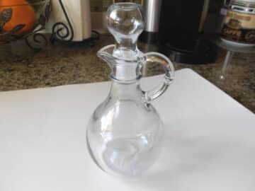 Empty maple syrup bottle on table.