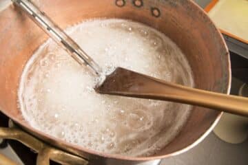 Pot of maple water boiling down with thermometer.