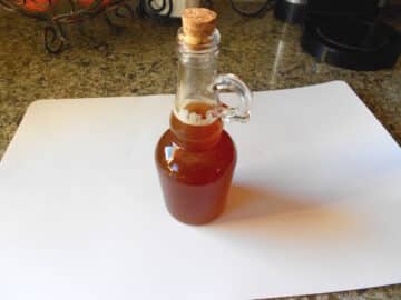 Bottle of maple syrup on counter.