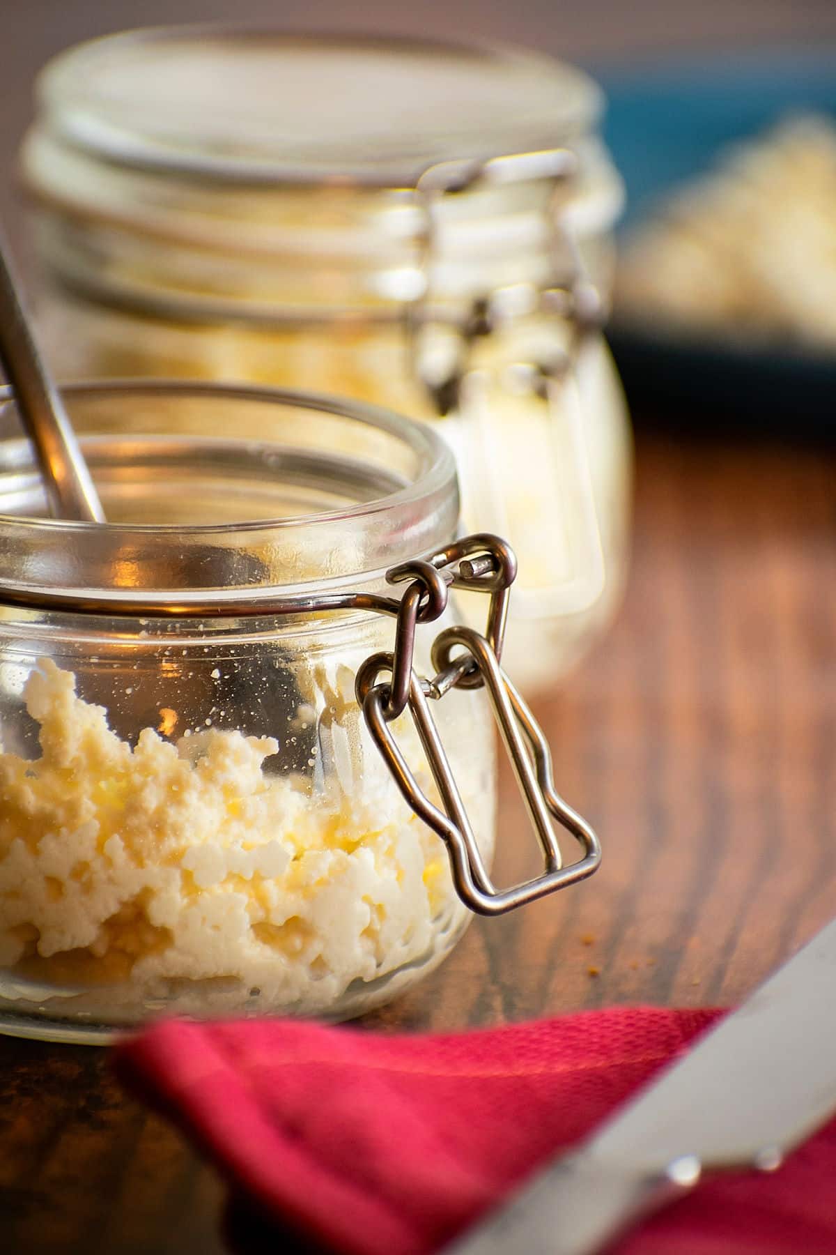 Ricotta cheese in jar on wooden background.