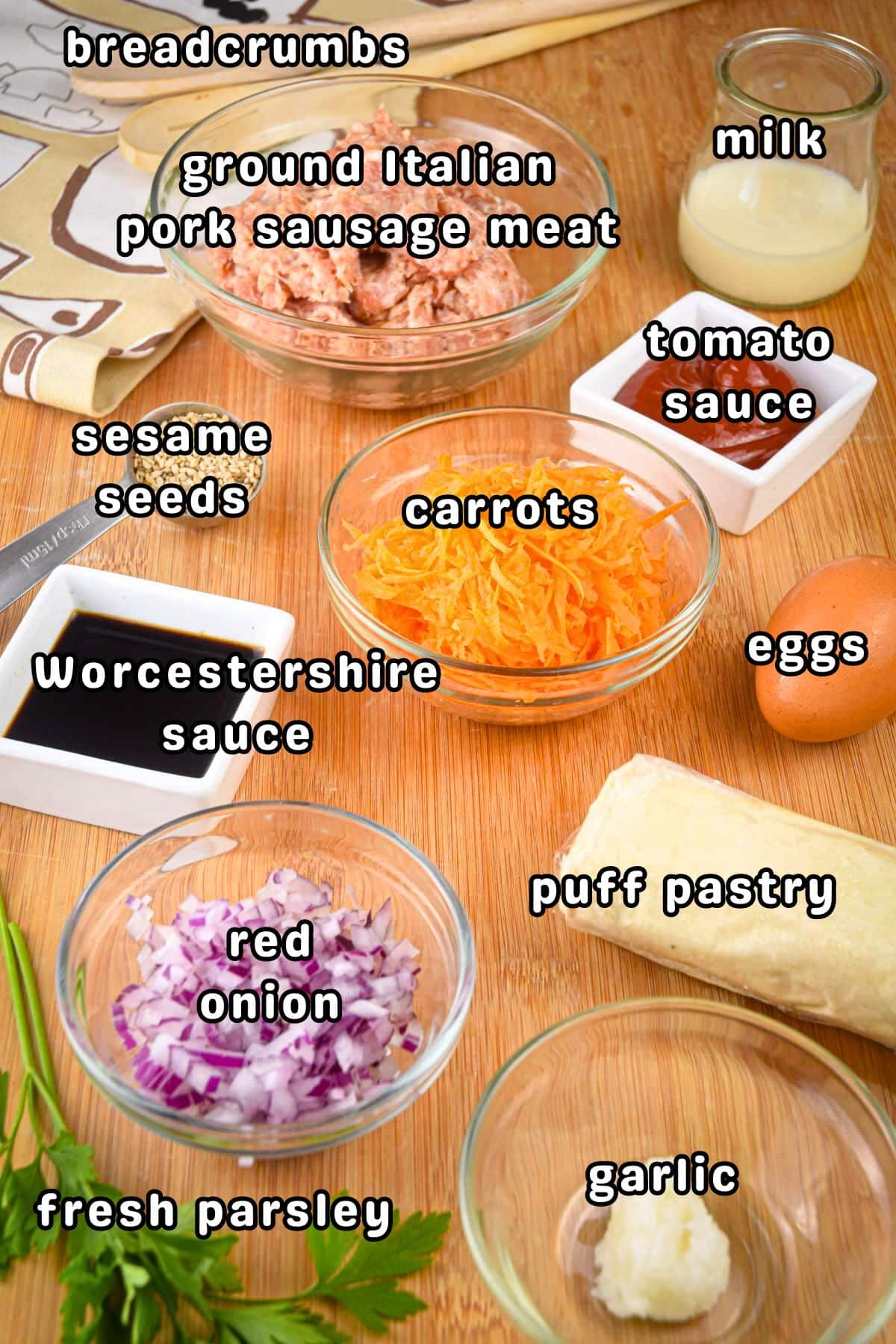 Sausage roll ingredients prepped and labeled on wooden background.