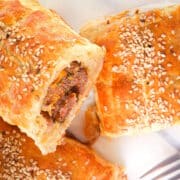 Sausage rolls in puff pastry with sesame seeds.