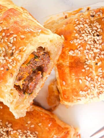 Sausage rolls in puff pastry with sesame seeds.