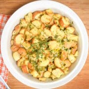 Thanksgiving stuffing/dressing in white bowl with fresh herbs.
