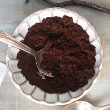 Vanilla bean powder in small dish with spoon.