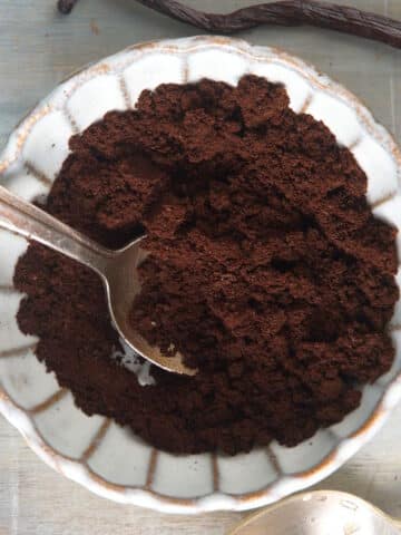 Vanilla bean powder in small dish with spoon.