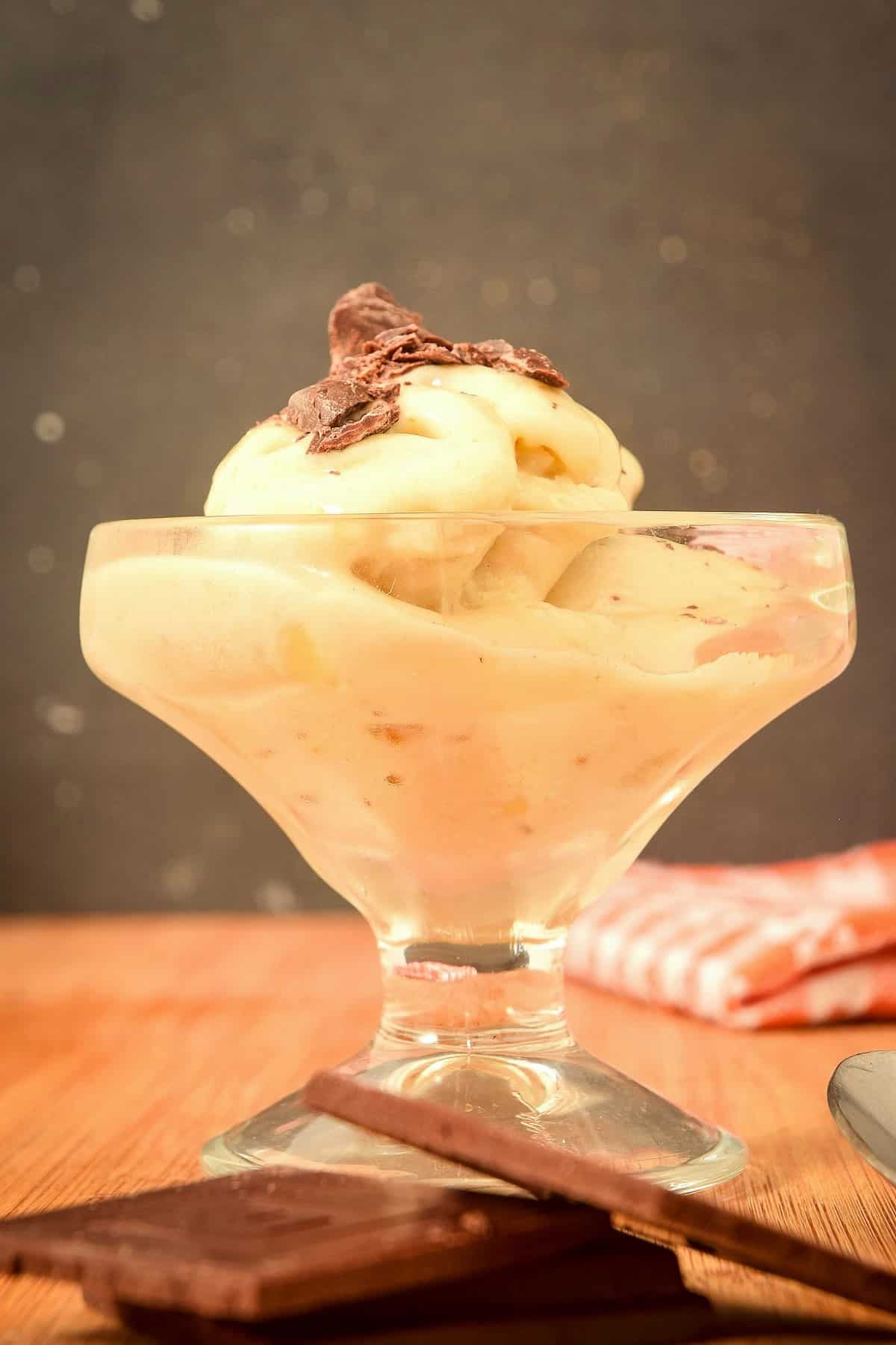 Banana nice cream with chocolate shavings in a dessert glass.