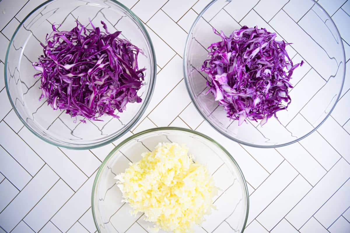 Red and green cabbage shredded in bowls.