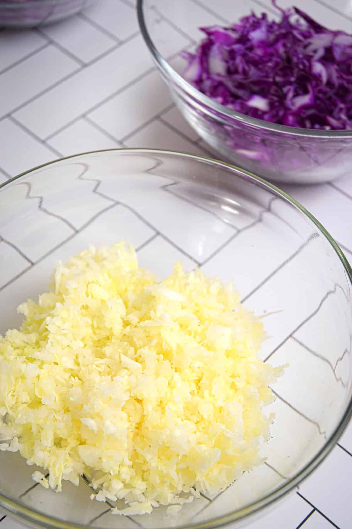 Green and red cabbage shredded in bowl.