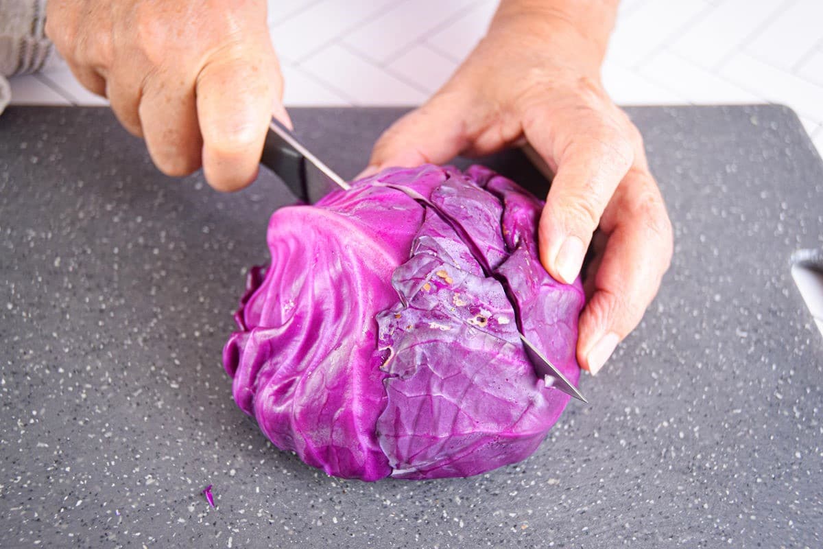 Red cabbage getting sliced into quarters.