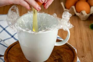 Egg cracking into mug.
