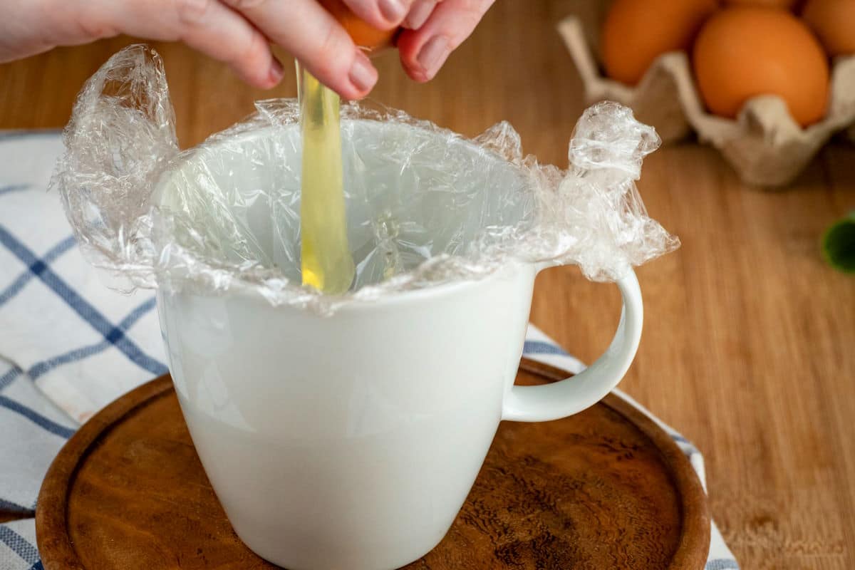 Egg cracking into mug.