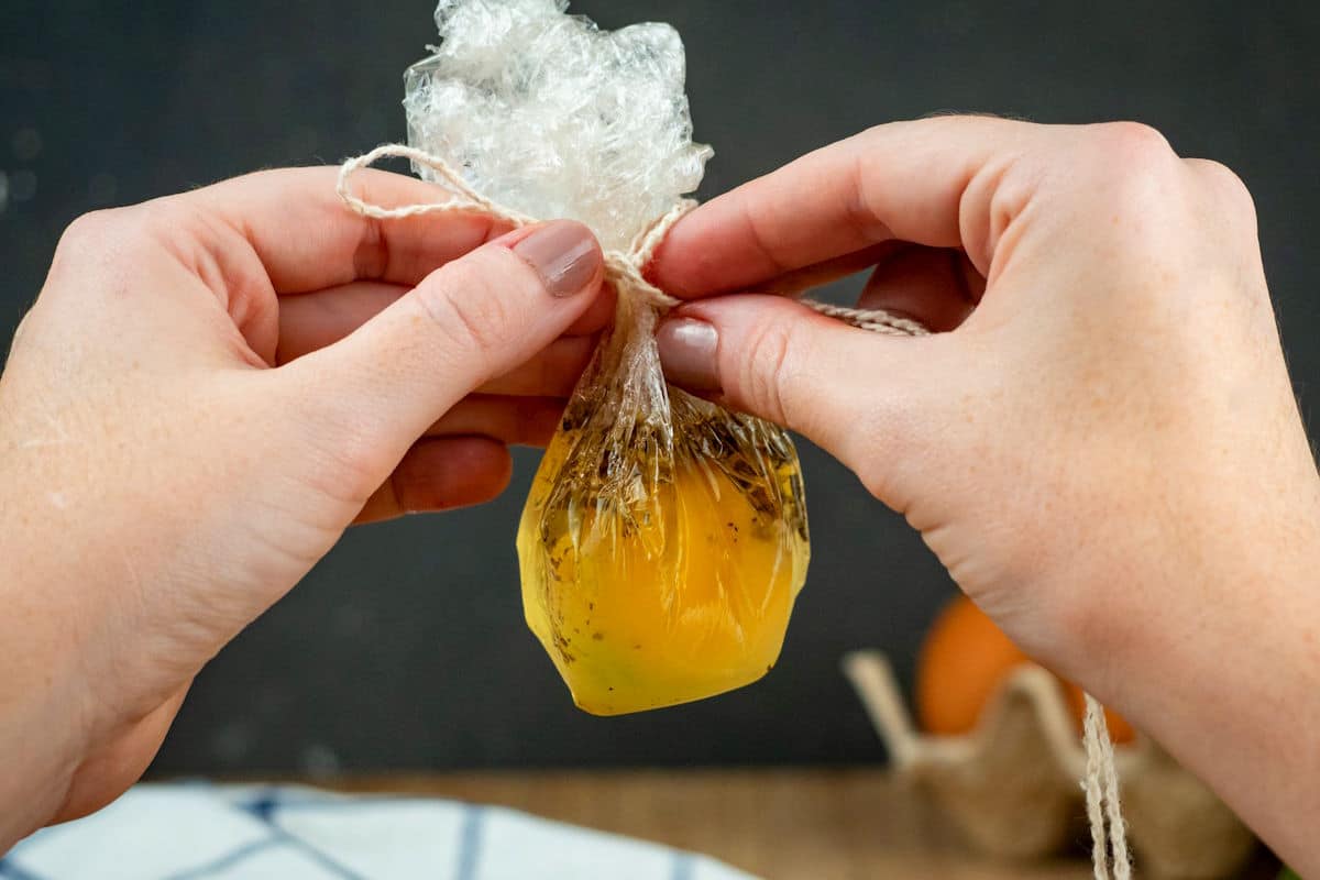 Raw egg in plastic wrap with twine.