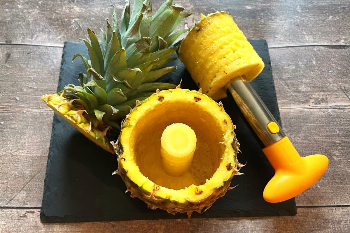 Pineapple corer with pineapple rings and empty pineapple rind.