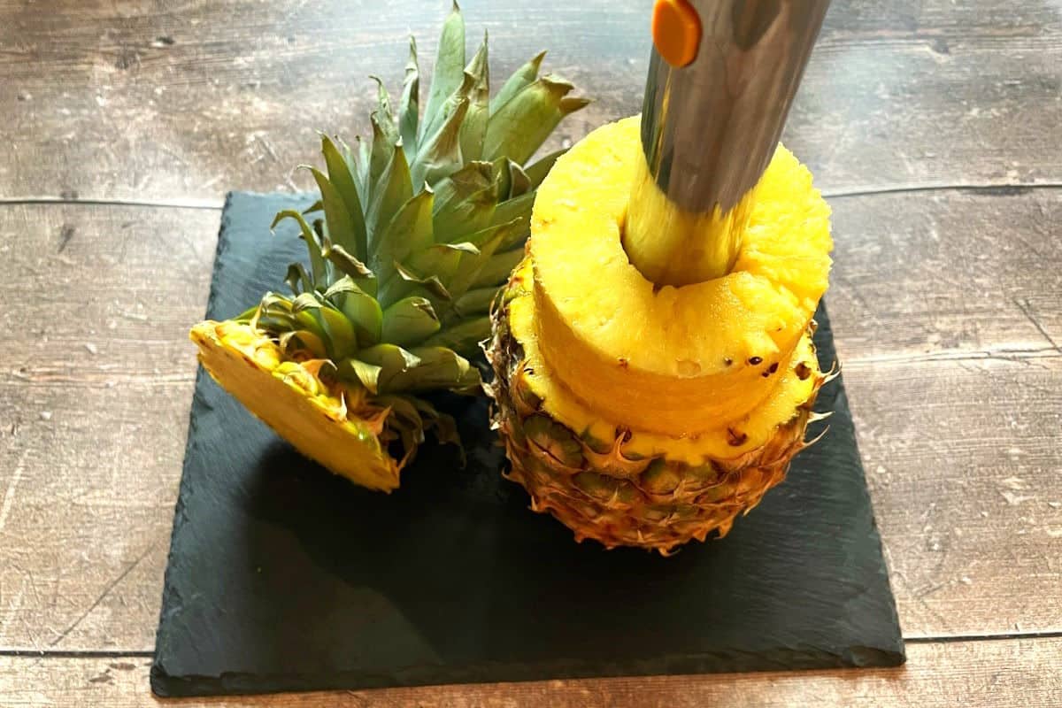 Pineapple corer pulling rings out of a pineapple.