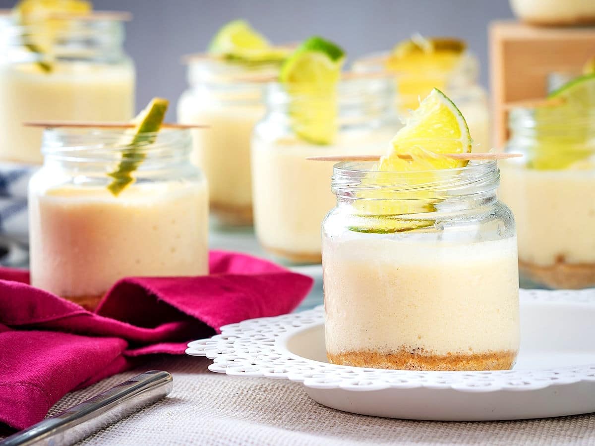 Iced lemon mousse in small jars with lime garnish.