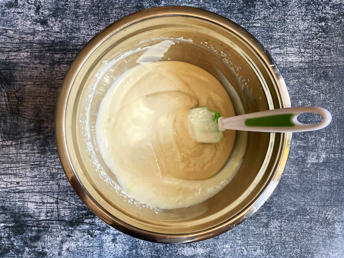 Whipped evaporated milk in bowl with spatula.
