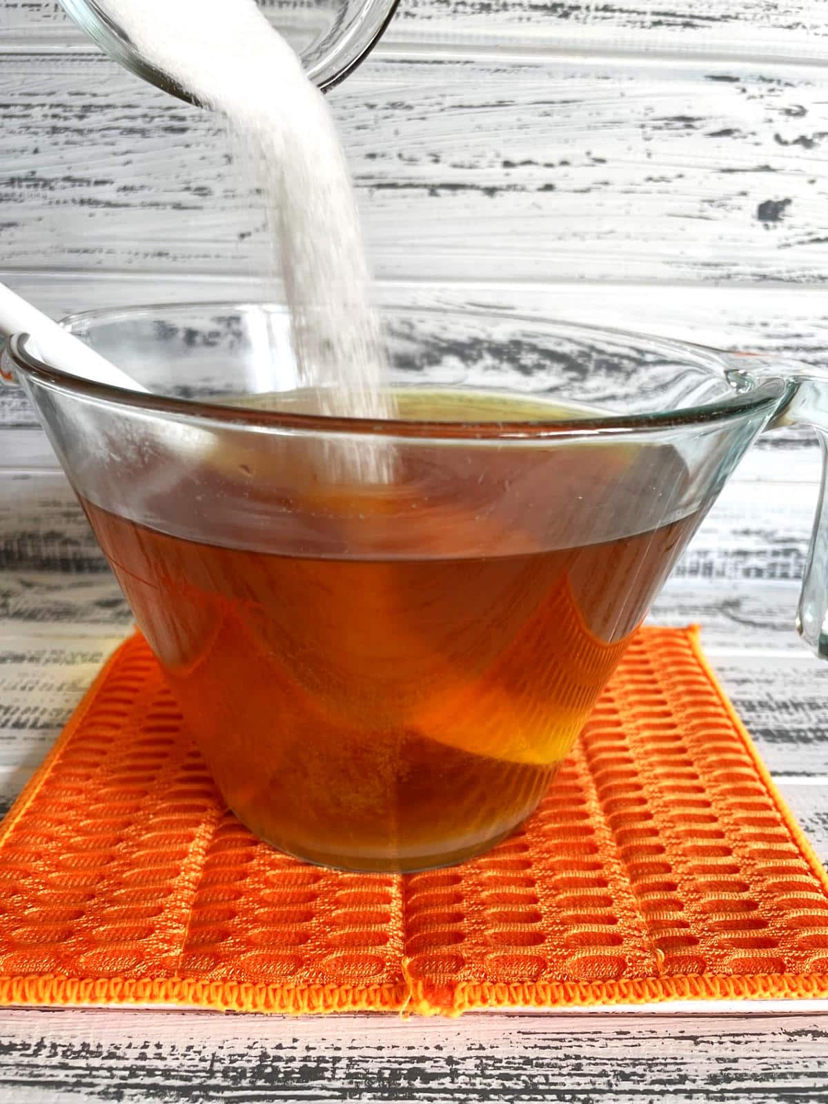 Sugar pouring into green tea.