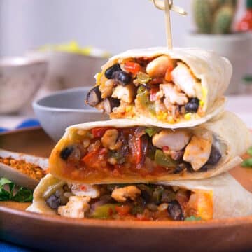 Kimchi burritos cut open and stacked with toothpick.