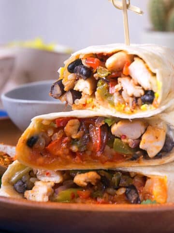 Kimchi burritos cut open and stacked with toothpick.